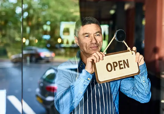 business owner changing open sign